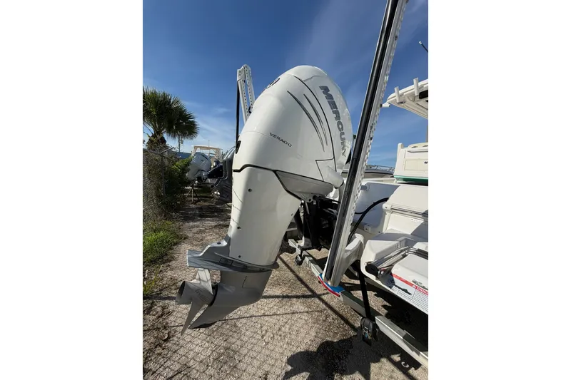 Slide: The Image of 2021 Caymas 28 HB boat with Mercury outboard motor, parked outdoors. - 26
