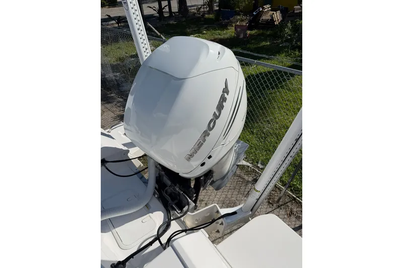 Slide: The Image of 2021 Caymas 28 HB boat with a Mercury outboard motor, parked outdoors. - 25