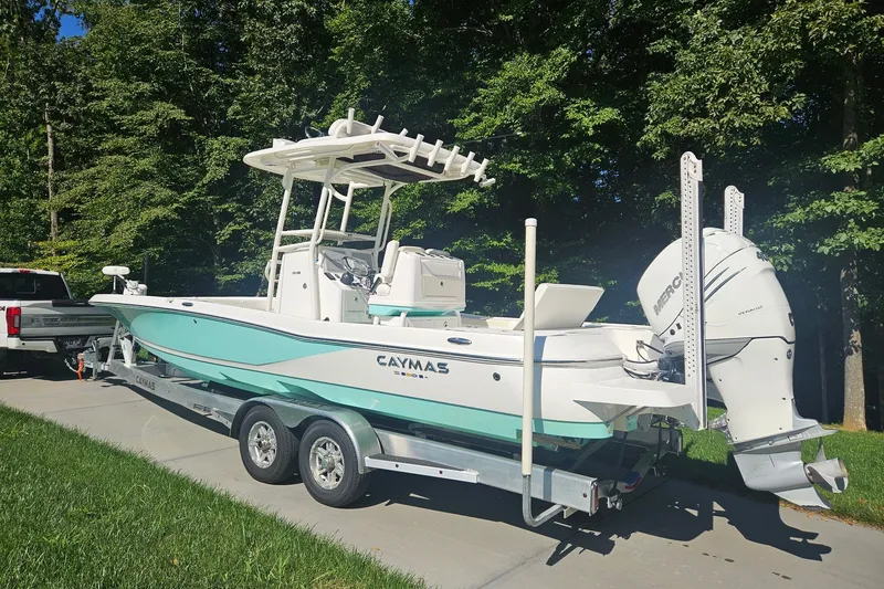 Slide: The Image of 2021 Caymas 28 HB boat on trailer, parked outdoors near trees. - 32
