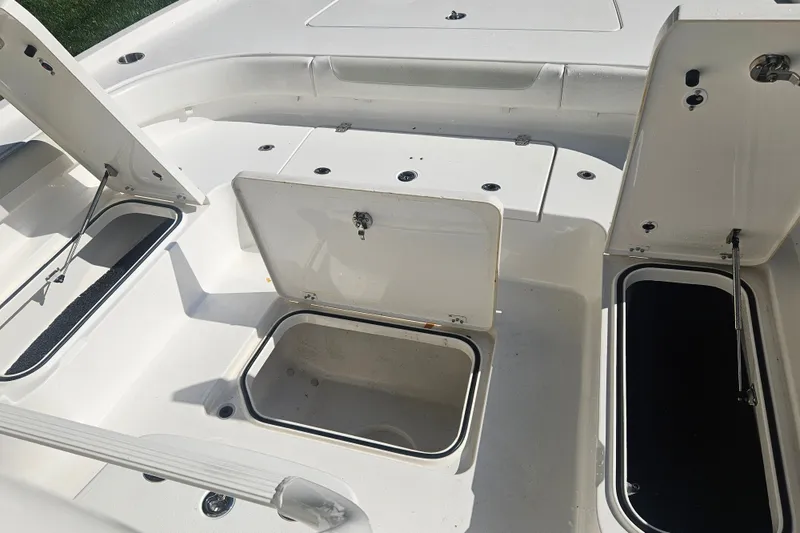 Slide: The Image of 2021 Caymas 28 HB boat storage compartments with open hatches, showcasing spacious interior design. - 13