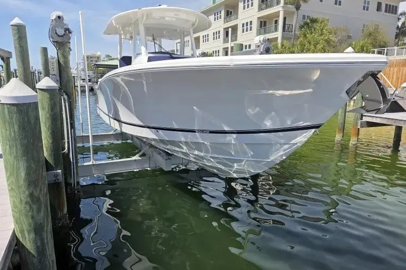 The Image of 2026 Regulator 35 boat docked at marina, reflecting on calm water. - 0