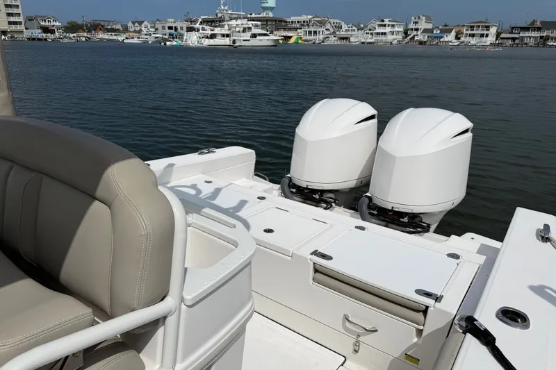 Slide: The Image of 2019 Everglades 273 Center Console boat with twin engines docked by waterfront homes. - 20