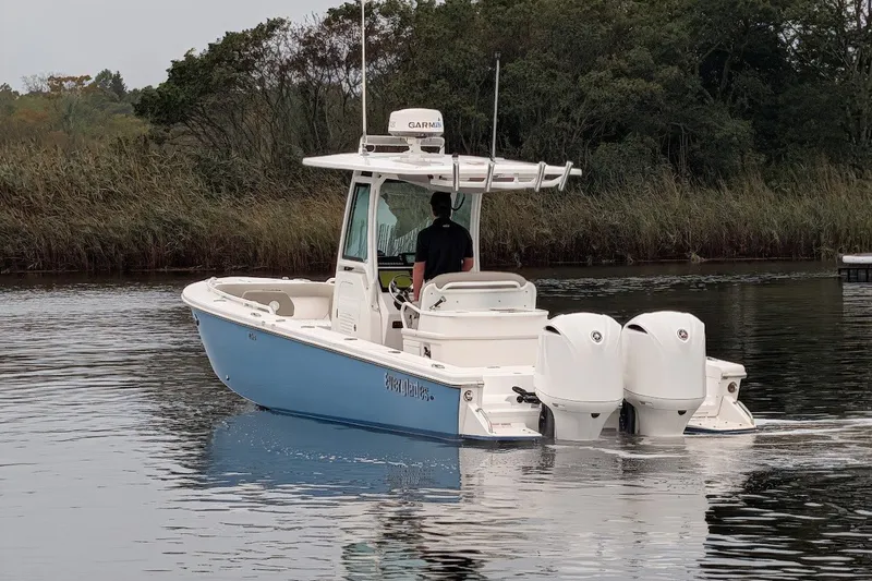 Slide: The Image of 2019 Everglades 273 Center Console boat with dual engines on a calm waterway. - 26