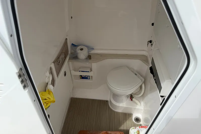 Slide: The Image of Interior of 2019 Everglades 273 Center Console boat bathroom with toilet and storage. - 16