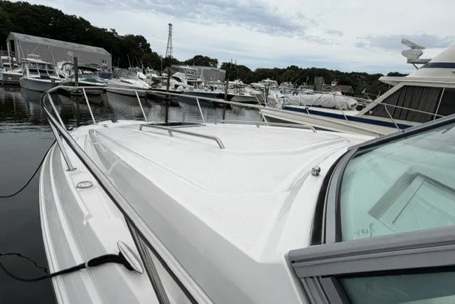Slide: The Image of 2015 Chaparral 310 Signature boat docked in a marina with other vessels. - 16
