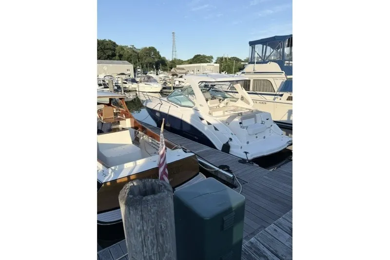 Slide: The Image of 2015 Chaparral 310 Signature boat docked at a marina under clear skies. - 7
