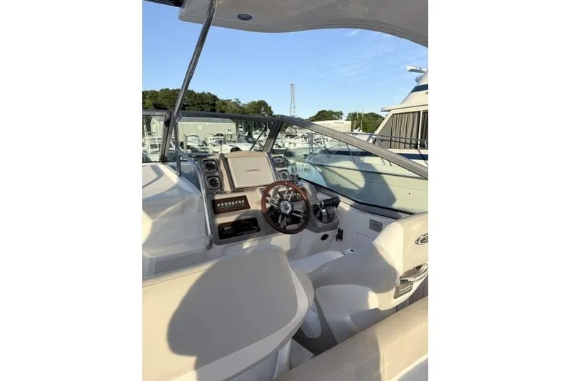 Slide: The Image of 2015 Chaparral 310 Signature boat cockpit with steering wheel and navigation system. - 12