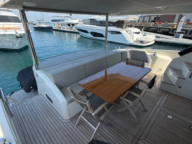 Slide: The Image of The image shows the aft deck of a 2022 Absolute 62 Fly with a wooden table and chairs. - 9