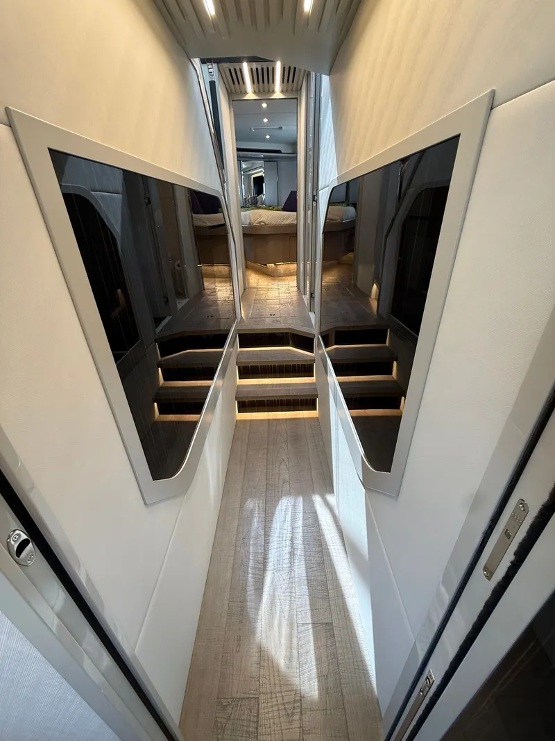 Slide: The Image of A sleek corridor with wooden flooring and modern mirrors leads to a luxurious bedroom. - 44