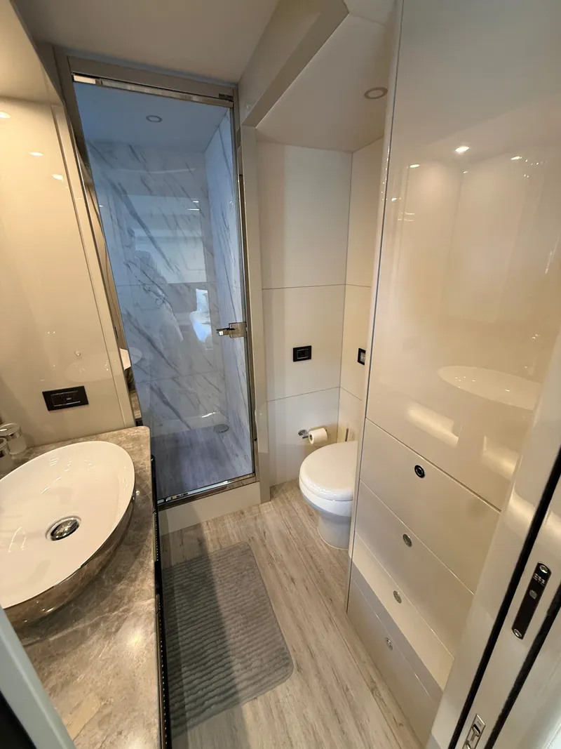 Slide: The Image of Luxurious bathroom with modern fixtures, sink, toilet, and a shower cabin with a glass door. - 47