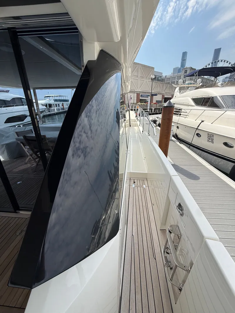 Slide: The Image of The 2022 Absolute 62 Fly is docked. It features a sleek design with large windows. - 15