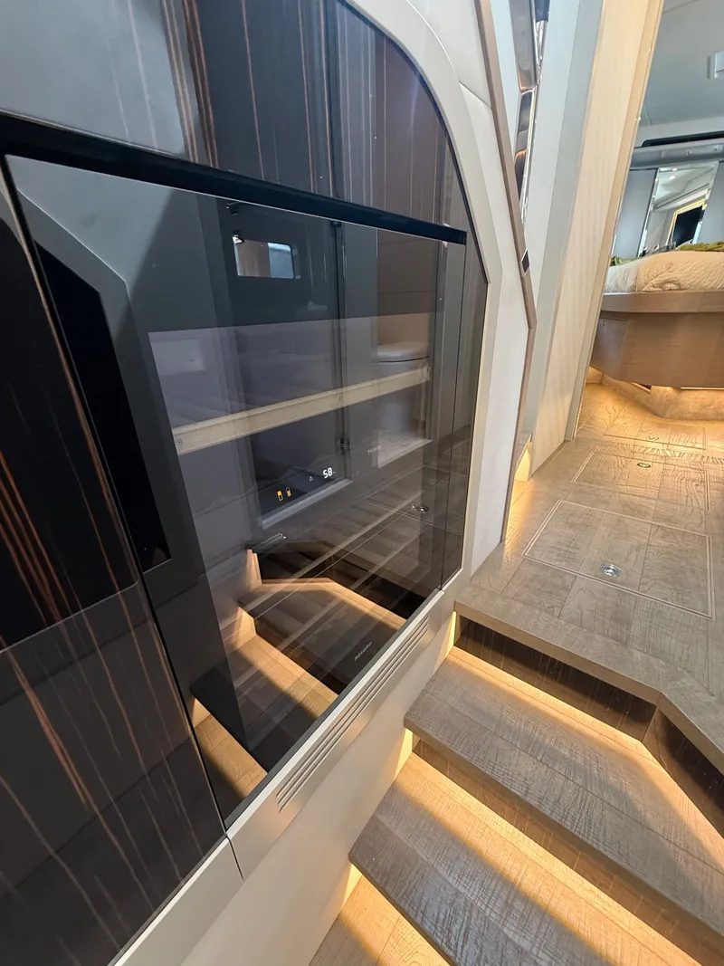 Slide: The Image of Interior of the 2022 Absolute 62 Fly with sleek wood paneling and illuminated stairs. - 45