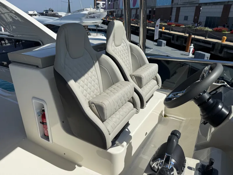 Slide: The Image of Two luxurious, padded seats at a yacht's helm, featuring a modern steering wheel and controls. - 31