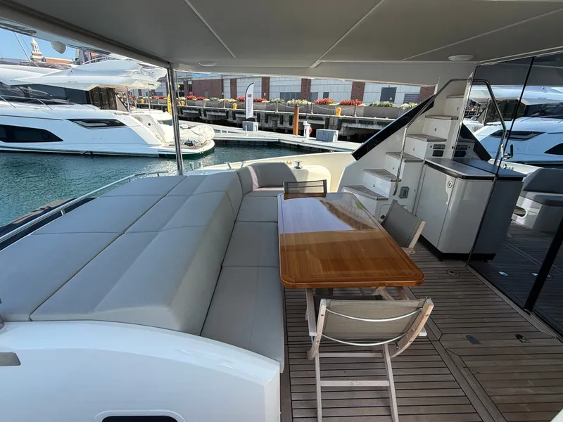 Slide: The Image of The 2022 Absolute 62 Fly features an elegant outdoor deck with a dining table and comfortable seating. - 6