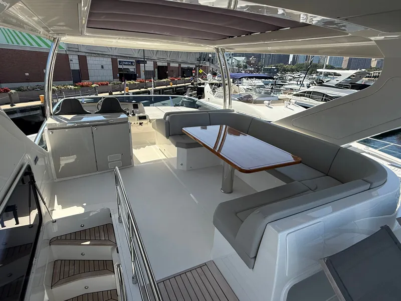 Slide: The Image of The 2022 Absolute 62 Fly features a sleek deck with seating and a table, perfect for relaxing. - 22