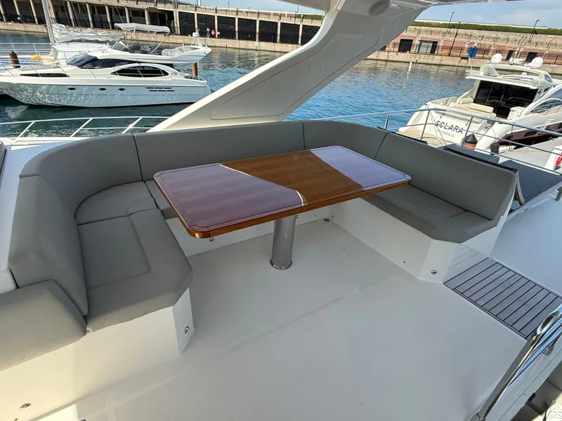 Slide: The Image of The image shows a yacht seating area with a wooden table and gray cushions. - 24