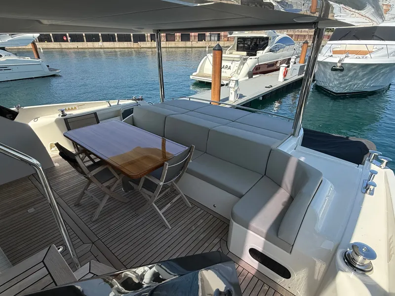 Slide: The Image of The image shows the aft deck of a luxury yacht with a sleek dining table and cushioned seating. - 7