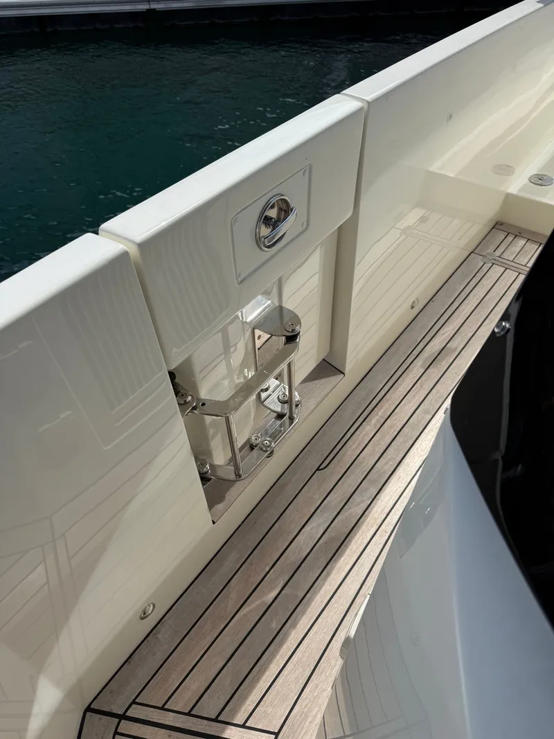 Slide: The Image of The 2022 Absolute 62 Fly features a sleek deck with wooden flooring and polished metal accents. - 14