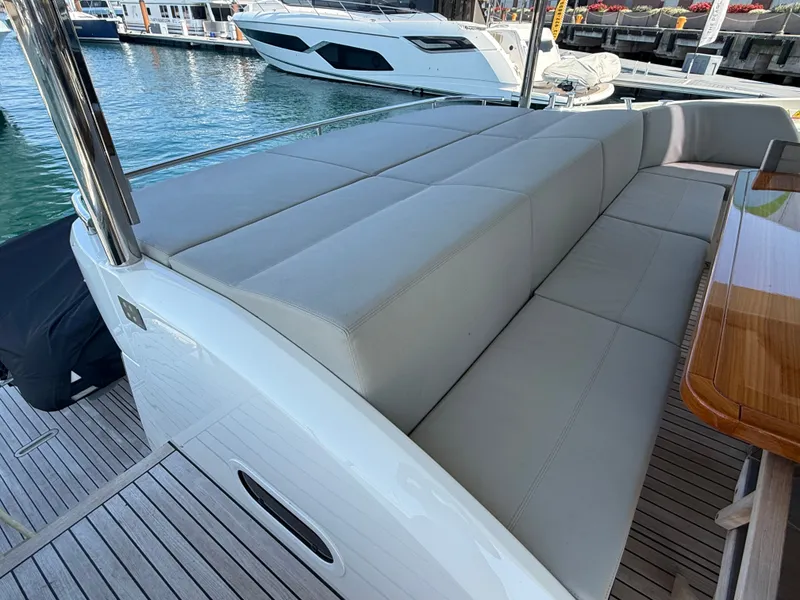 Slide: The Image of The image shows the stern of a luxury yacht with beige cushioned seating and a wooden table. - 5