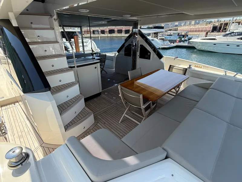 Slide: The Image of The 2022 Absolute 62 Fly features a sleek aft deck with seating area and table. - 12