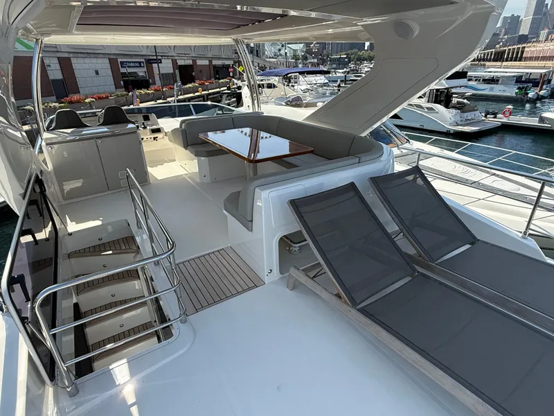 Slide: The Image of The image shows the deck of a luxury yacht with sun loungers and a dining table. - 21
