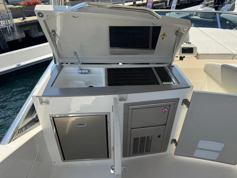 Slide: The Image of The 2022 Absolute 62 Fly features an outdoor kitchen with a sink, grill, and refrigerator. - 29