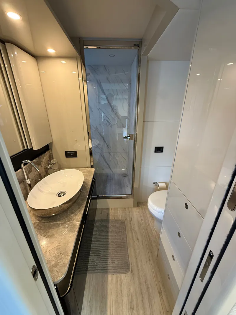 Slide: The Image of Bathroom on a 2022 Absolute 62 Fly with modern sink, shower, and toilet. - 48