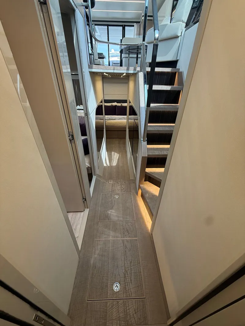 Slide: The Image of Interior of a modern boat with wooden floors, stairs, and a sleeping area in the background. - 42
