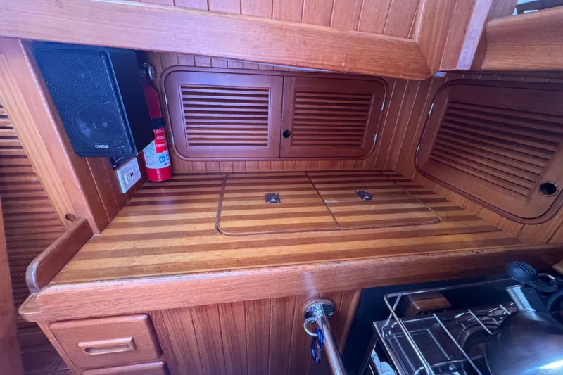 Slide: The Image of Wooden interior of 1986 Tashing Tashiba 31 yacht galley with storage and fire extinguisher. - 13