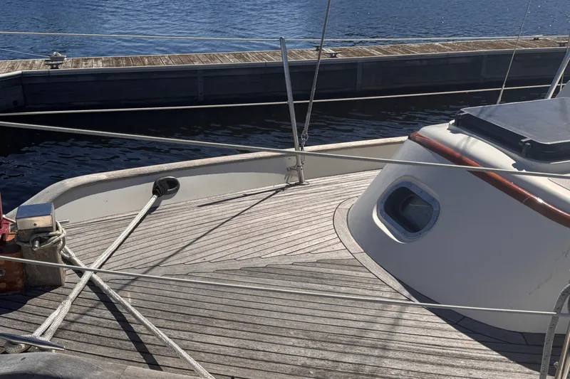 Slide: The Image of 1986 Tashing Tashiba 31 sailboat deck with wooden finish, docked by the water. - 7