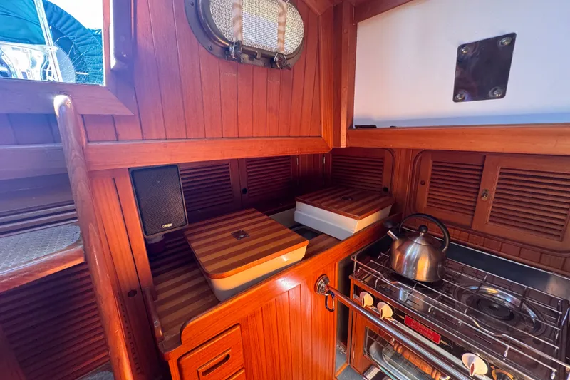 Slide: The Image of Wooden interior of 1986 Tashing Tashiba 31 yacht kitchen with stove and kettle. - 14