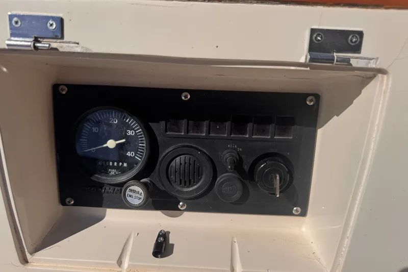 Slide: The Image of Control panel of a 1986 Tashing Tashiba 31 boat, featuring RPM gauge and ignition key. - 32
