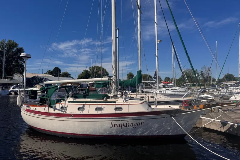 The Image of 1986 Tashing Tashiba 31 sailboat docked at marina under clear blue sky. - 0
