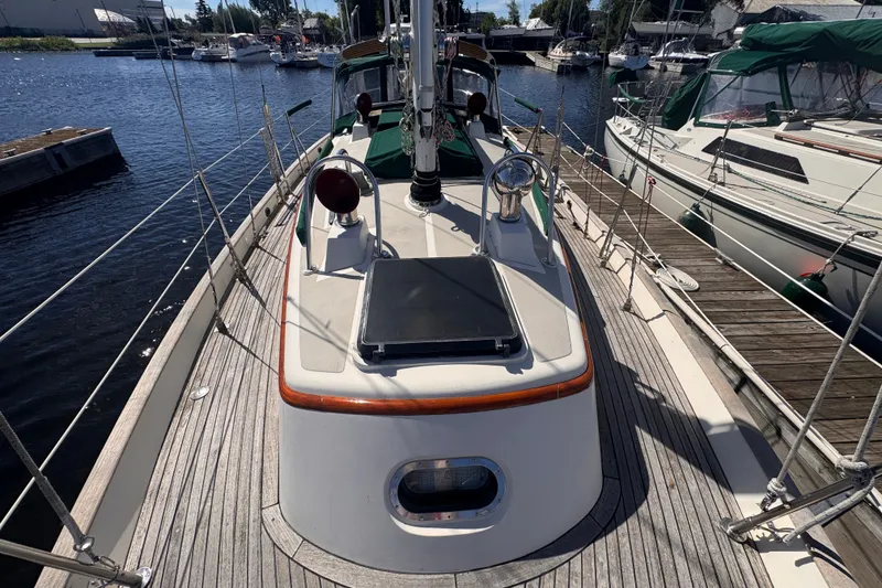 Slide: The Image of Sailboat Tashing Tashiba 31, 1986 model, docked at marina with wooden deck. - 2