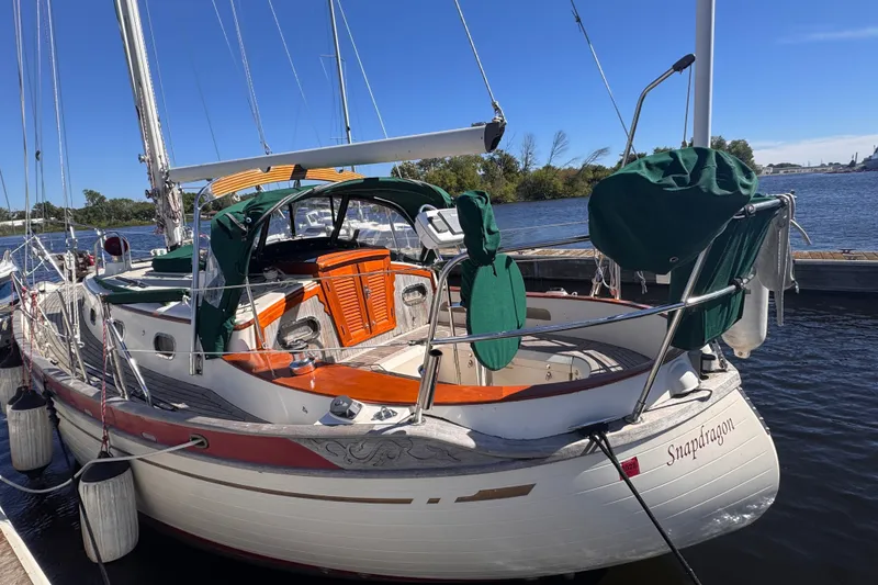 Slide: The Image of 1986 Tashing Tashiba 31 sailboat docked, featuring green covers and wooden accents. - 3