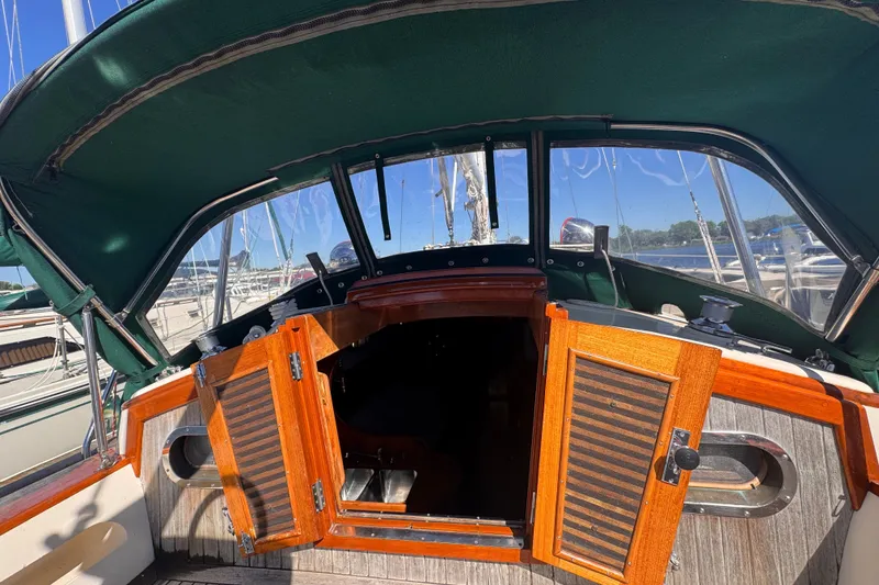 Slide: The Image of 1986 Tashing Tashiba 31 sailboat cockpit with open wooden hatch and green canopy. - 12