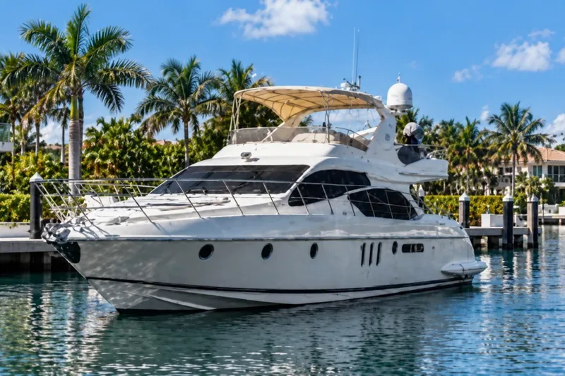 The Image of Luxurious 2004 Azimut 62 yacht docked in a tropical marina setting. - 0