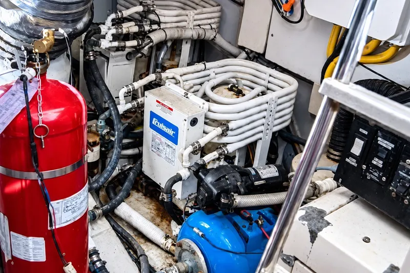 Slide: The Image of Engine room of a 2004 Azimut 62 yacht, featuring mechanical equipment and fire extinguisher. - 37