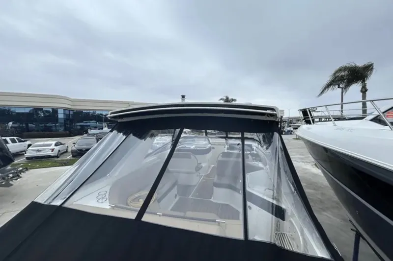 Slide: The Image of 2024 Sea Ray SLX 310 boat with covered cockpit, parked outdoors on a cloudy day. - 23