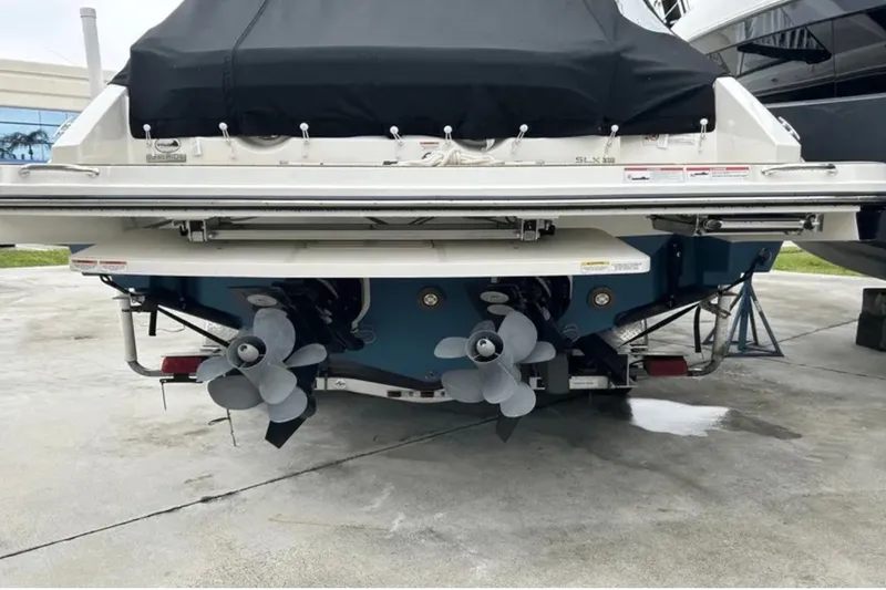 Slide: The Image of 2024 Sea Ray SLX 310 boat with dual propellers, docked on concrete. - 21