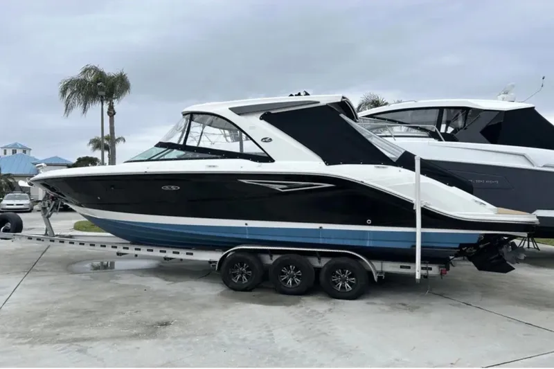 Slide: The Image of 2024 Sea Ray SLX 310 boat on trailer, parked outdoors. - 14