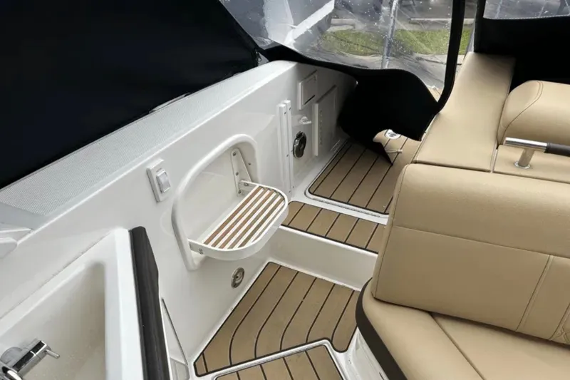 Slide: The Image of 2024 Sea Ray SLX 310 interior with beige seating and teak-style flooring. - 35
