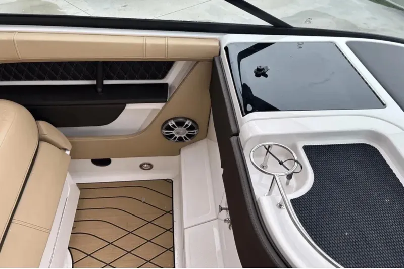 Slide: The Image of 2024 Sea Ray SLX 310 interior with tan seating, speaker, and cup holder. - 40