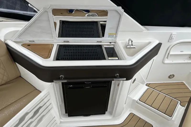 Slide: The Image of 2024 Sea Ray SLX 310 boat interior with kitchenette, featuring grill and sink. - 37