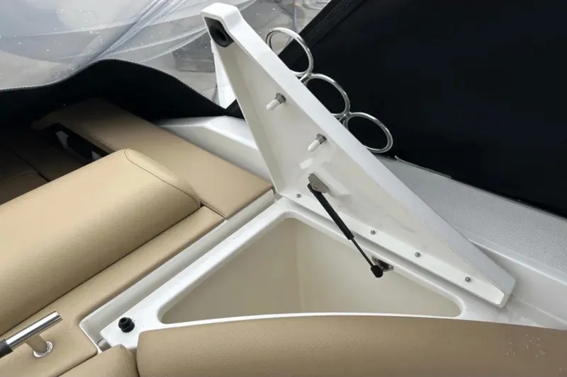 Slide: The Image of 2024 Sea Ray SLX 310 boat storage compartment with beige seating and cup holders. - 31