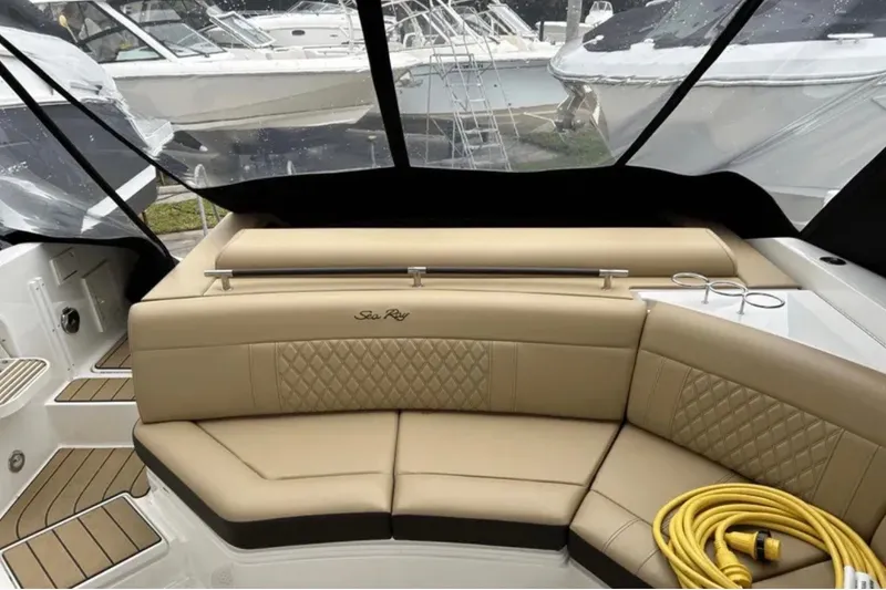 Slide: The Image of 2024 Sea Ray SLX 310 boat interior with beige seating and cup holders. - 34