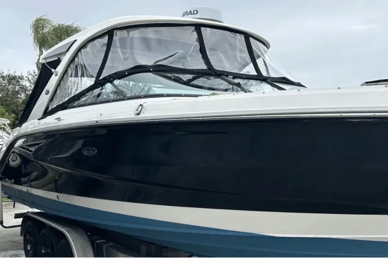 Slide: The Image of 2024 Sea Ray SLX 310 boat with sleek black and white design on a trailer. - 16