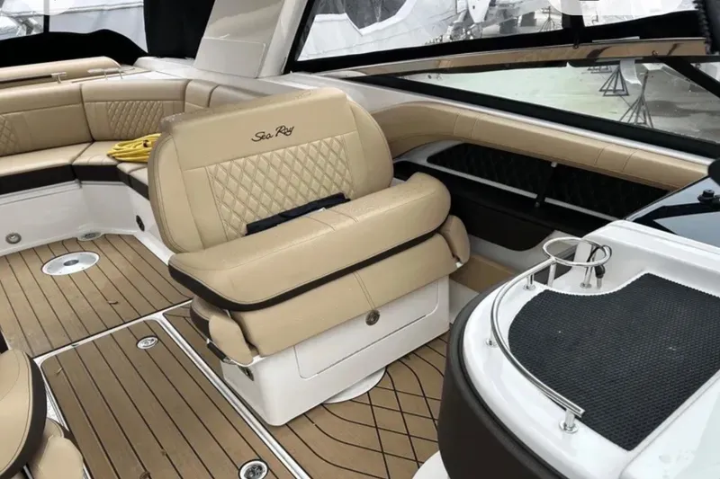 Slide: The Image of 2024 Sea Ray SLX 310 boat interior with beige seating and wood flooring. - 43