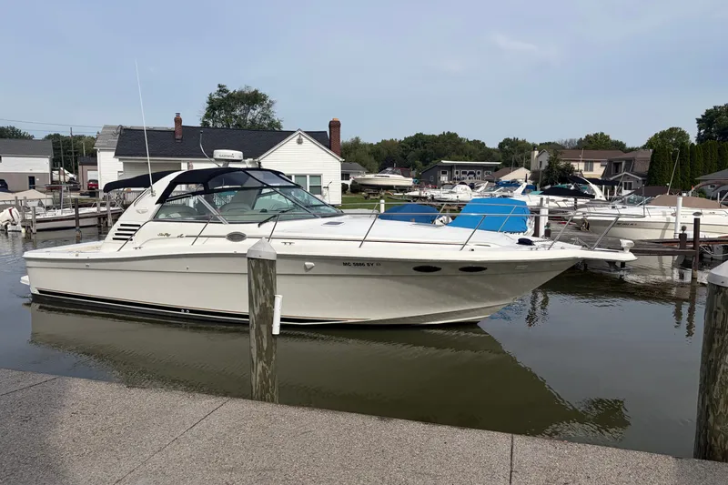 The Image of 1999 Sea Ray 370 Express Cruiser docked at a marina, surrounded by other boats. - 1