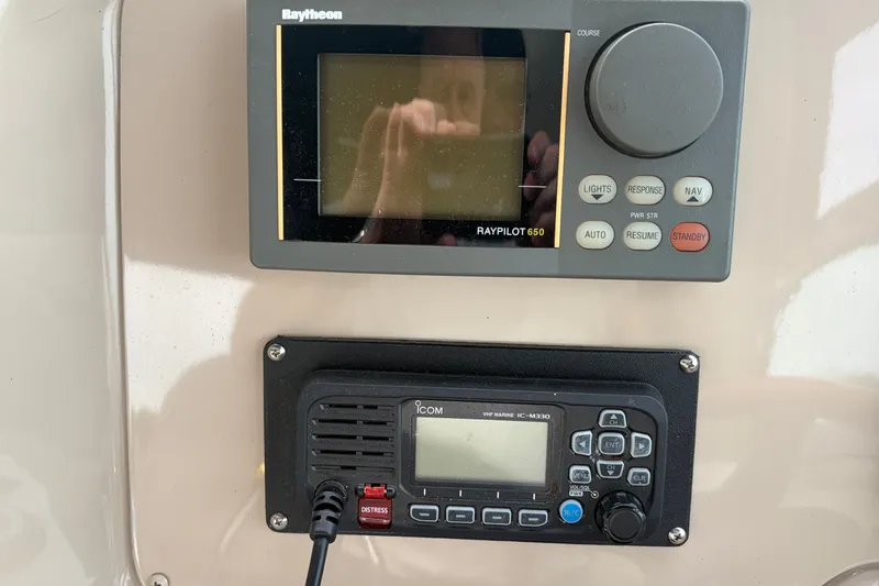 Slide: The Image of Control panel of a 1999 Sea Ray 370 Express Cruiser with Raytheon and Icom devices. - 24